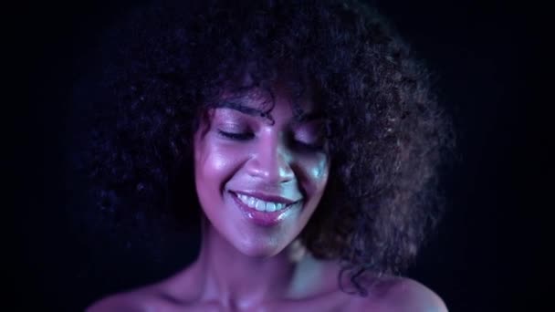 Portrait of young mixed race girl. Healthy skin concept. Positive cute woman with make-up posing in dark room on black background. — Stock Video