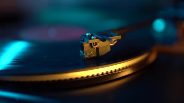 Giradiscos de vinilo de lazo de cinemagraph con su lápiz óptico a lo largo de la placa de música. Luz de neón. Retro-style spinning record vinyl player. De cerca. — Vídeo de stock