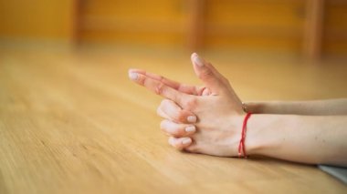 Sarı stüdyoda yoga yapan genç bir kadın. Parçalanmış sicim yapan bir kız. Vajra ok mudrasında ellerini kapat.