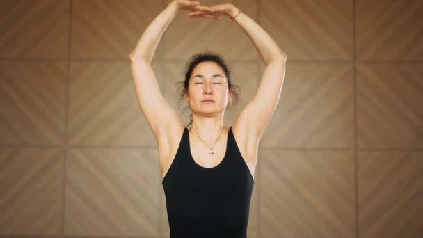 Flicka med orientalisk utseende gör stretching, andningsövningar-Pranayama. Ung vacker kvinna som tränar yoga på ljus minimalistisk studioklass rum. Hälsa livsstilskoncept — Stockvideo