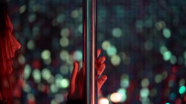 Pylone 'la dans eden kadın. Kız elini direğe koyar ve seksi dansını gece kulübü ya da stüdyoda başlatır..