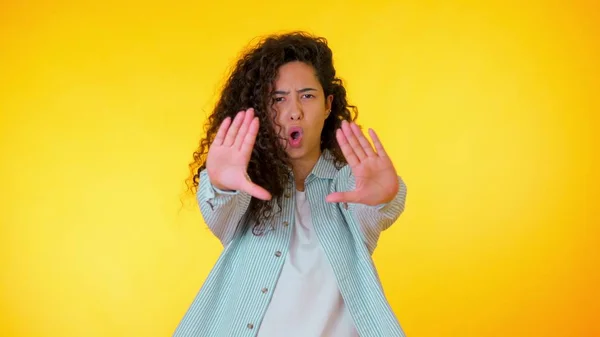 Une femme énervée lève la main pour dire non à l'arrêt. Regard sceptique et méfiant, se sentant en colère contre quelqu'un. Fille hispanique expressions faciales, émotions, sentiments. Langage corporel — Photo