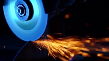 Kaynakçı taşlama yakın çekim modern ekipman kullanarak çelik ve demir pürüzsüzler. Endüstriyel üretim, çilingir sanayi konsepti. Taşlama tekerleğinden kıvılcımlar.