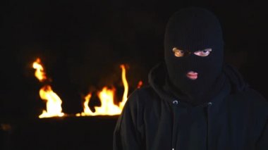 Protestocu aktivistin geceleri yanan barikatlara karşı maskesi. 