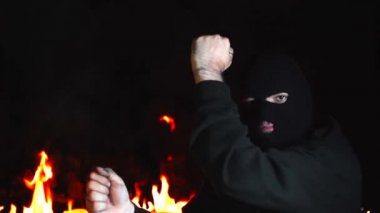 Balaclava'da dans eden ultras man'ın yanan gece ateşine karşı portresi