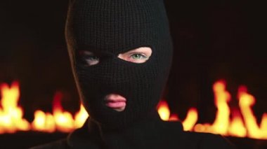 Yanan gece ateşine karşı maskeli kadın ultras veya protestocu portresi