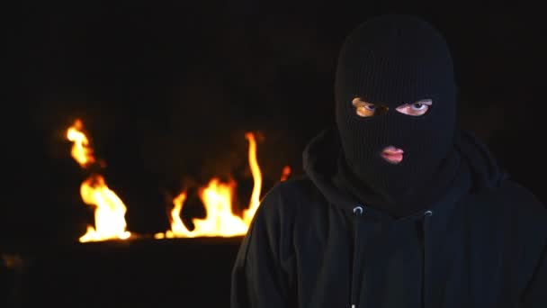 Portrait d'un militant en masque contre les barricades incendiées la nuit . — Video