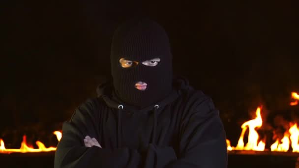 Portret van de mens in Balaclava toont hoofd bevestigende gebaar tegen brandende vuur — Stockvideo