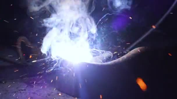 Travailleurs de meulage et de soudage dans une usine. Soudage sur une installation industrielle. Au ralenti. Flashs et beaucoup d'étincelles provenant des travaux de soudage sur le chantier dans l'obscurité — Video