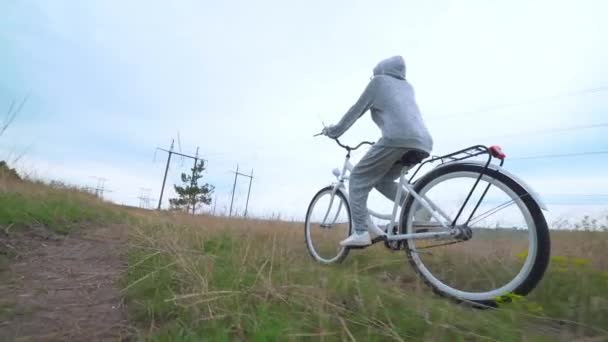 Beyaz geçmişe dönük bisiklet süren bir kadın. — Stok video