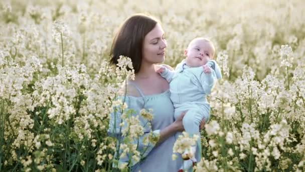 Portret van jonge moeder met pasgeboren zoon met plezier in geel veld. Liefde, familie, Joy concept. — Stockvideo