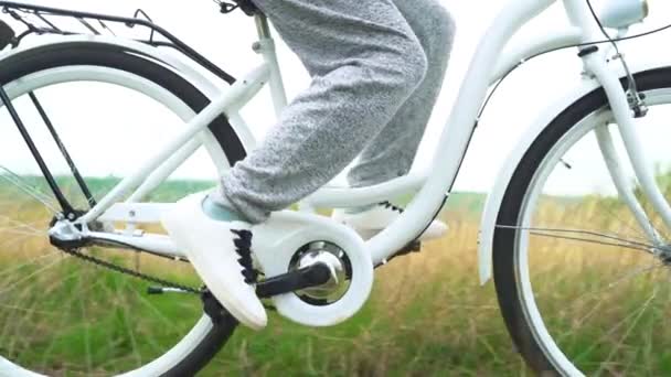 Benen van vrouw in witte schoenen rijden retro fiets platteland alleen — Stockvideo