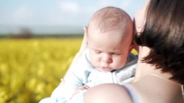 Sarı alanda eğlenceli yenidoğan bebek ile Genç Anne portresi. Aşk, Aile, sevinç konsepti
