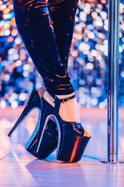 나이트 클럽에서 철탑과 섹시한 여자 폴 춤 또는 스트립의 발 뒤꿈치. 빛나는 배경 무대에서 스트리퍼 소녀. — 스톡 사진