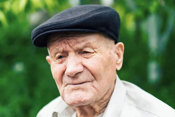 Régi Senior portré. Nagyszülő kalapban. 90 plusz év. Portré: öreg, idős, magány, az ember sok ráncok az arcon. Közeli fel egy töprengő öregember ül egyedül a szabadban. — Stock Fotó