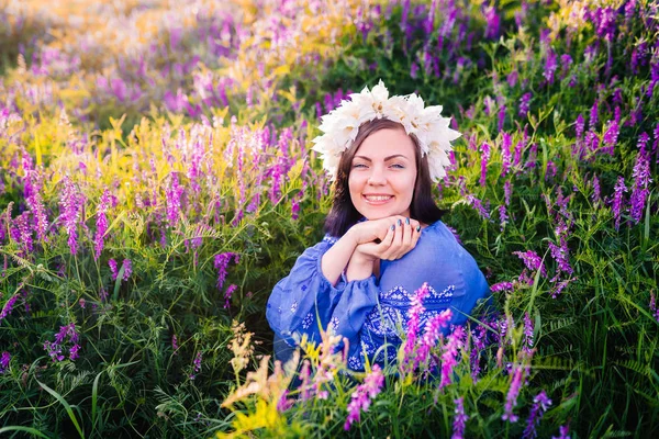 Молода красива жінка з квітковим вінком сидить у фіолетовому полі. Портрет дівчини в блакитному одязі . — стокове фото