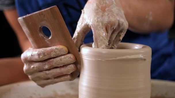 Fabricación de cerámica tradicional, hombre profesor muestra los fundamentos de la cerámica en el estudio de arte. Artista opera las manos, que suavemente la creación de forma correcta jarra hecha a mano de arcilla . — Vídeo de stock