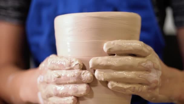 Tradiční keramické tvorby, muž učitel ukazuje základy keramiky v ateliéru. Umělec pracuje rukama, které jemně vytváření správně tvarované džbán ručně vyrobené z hlíny. — Stock video