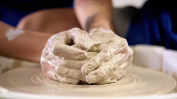 L'homme travaille ses mains avec de l'argile. Processus de création de produit à partir d'argile sur la roue des potiers. Vue latérale de l'artisan faisant pot ou cruche. Propriétaire de petite entreprise en atelier . — Video