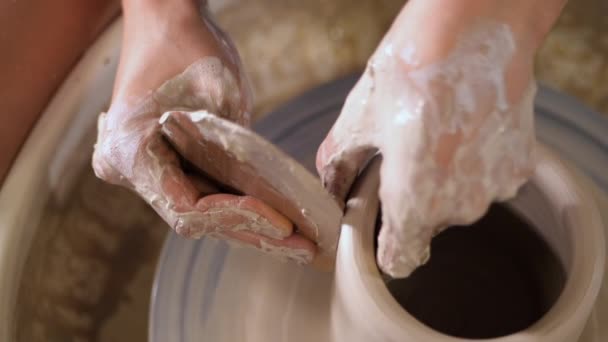 Fabricación de cerámica tradicional, hombre profesor muestra los fundamentos de la cerámica en el estudio de arte. Artista opera las manos, que suavemente la creación de forma correcta jarra hecha a mano de arcilla . — Vídeo de stock