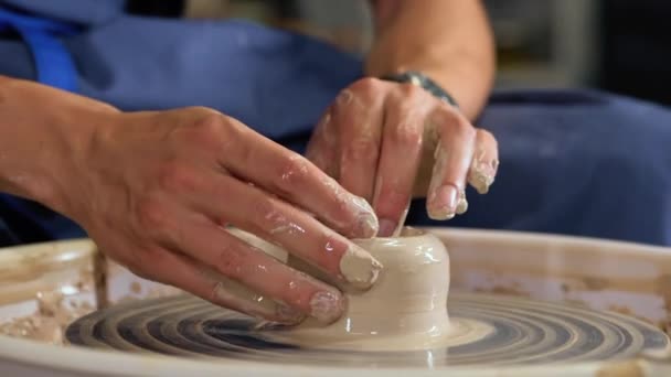 Досвідчений гончар формує глиняний виріб глечик з гончарними інструментами . — стокове відео