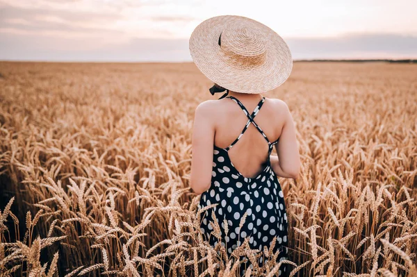 Donna irriconoscibile in abito stile retrò e cappello in posa nel campo di grano dorato. Viaggio, raccolto, natura, vecchio concetto di moda . — Foto Stock