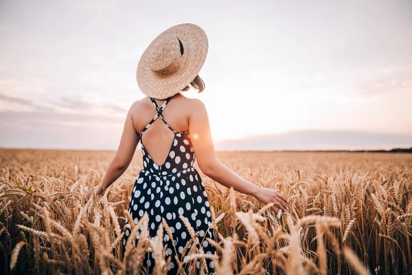 Donna irriconoscibile in abito stile retrò e cappello in posa nel campo di grano dorato. Viaggio, raccolto, natura, vecchio concetto di moda . — Foto Stock