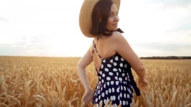 Retro giyinmiş kız hasır şapka ve siyah elbise gün batımında buğday alanında etrafında dönen. Neşeli, neşeli, mutlu kadın.