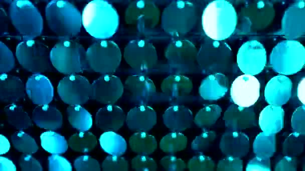 Shiny kinetic surface panel illuminated by blue light in luxury boutique. Flickering background for interruptions or text savers. Mirror sequins sway by wind blowing. — Stock Video