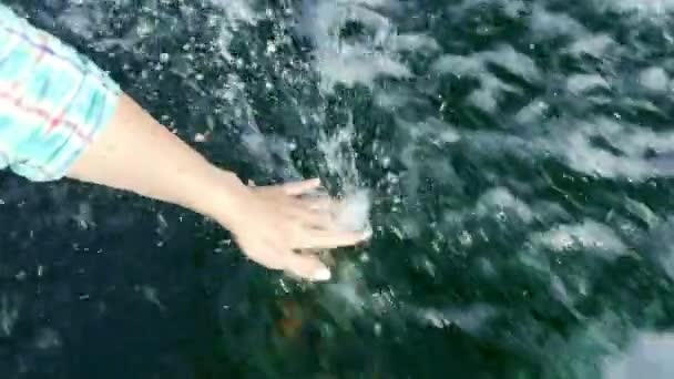 La mano femenina toca el río claro o el agua de mar durante el paseo en barco o yate de verano . — Vídeo de stock