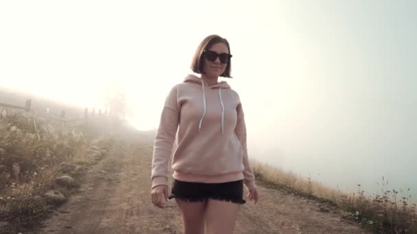 Mujer caminando a la cámara. Foggy fondo de la mañana temprano. Naturaleza en las montañas Cárpatas. Concepto de viaje . — Vídeo de stock