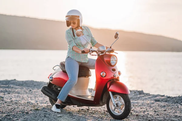 Retrato de chicas lindas. Mujer con casco y gafas de sol sentada en bicicleta retro roja en el fondo del río puesta de sol. Tono vintage cinematográfico. Copiar espacio —  Fotos de Stock