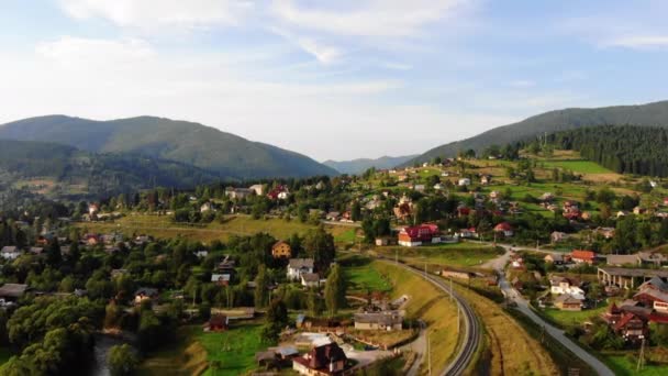 Вид на селище в горах від літаючого безпілотника. Літо в Європі Карпати. Концепція польоту, природа, захоплююча краса нашої планети — стокове відео