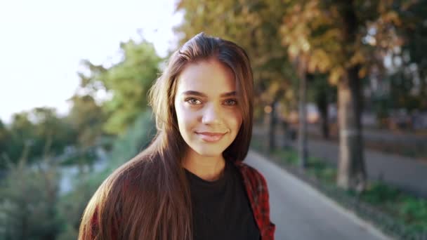 Ragazza in camicia a quadri rossa sorride, gode della vita.Concetto di vita studentesca, libertà, gioventù moderna. Rallentatore — Video Stock