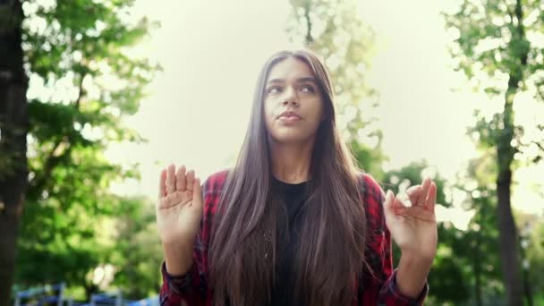 Fiatal nyugodt nő pihentető, meditál a zöld parkban. Lány elutasítja a stresszt, és úgy helyzet, megnyugtatja, lélegzik mélyen. Jóga, Zen, egészségügyi életmód koncepció. — Stock videók