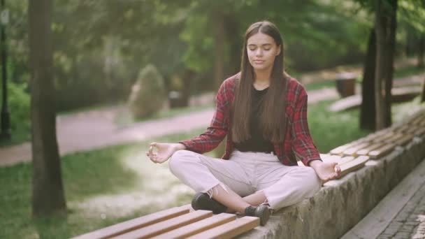 Jonge mooie vrouw mediteren, ze voelt vrede in Megalopolis. Zen, vrijheid, kalmte concept — Stockvideo