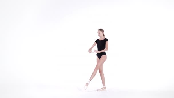 Ballerina in black bodysuit practicing in dance studio or gym. Woman dancing classical pas. Alone warming up before performance. Amazing dance. Slow motion — Stock Video