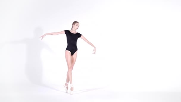 Ballerina in black bodysuit practicing in dance studio or gym. Woman dancing classical pas. Alone warming up before performance. Amazing dance. Slow motion — Stock Video