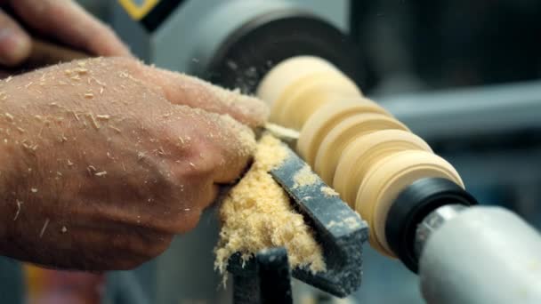 Timmerman werkt in huis workshop. Close-up van houtsnippers die uit de machine vliegen. Proces van ambachtelijke handenarbeid. — Stockvideo