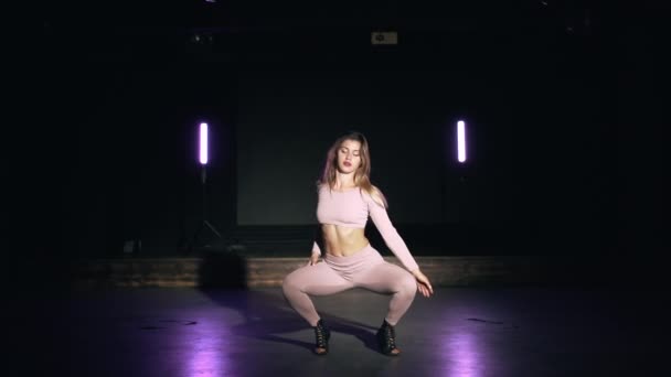 Retrato de menina bonita em rosa naipe apertado sensualmente dançando em estúdio escuro com lamps.Concept roxo de coreografia, dança, desempenho — Vídeo de Stock