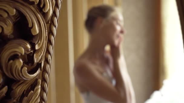 Ung vacker flicka sitter nära lyxig spegel och beundrar sig själv. Porträtt av kvinna i defocus. Oigenkännlig dam. slow motion — Stockvideo