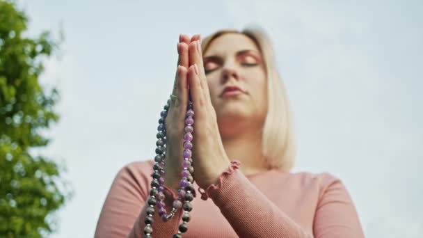 Mujeres manos con cuentas de mala o rosario juntos simbolizan la oración y la gratitud. Mudra. Concepto de yoga. Chica concentrada de pie con las manos en namaste y meditando o rezando . — Vídeos de Stock