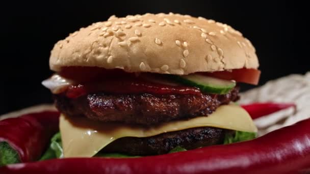 맛있는 햄버거, 패스트 푸드 컨셉. 집에서 갓 구운 뜨거운 햄버거에 붉은 고추, 고기 패티, 토마토,오이, 상추, 양파, 참깨등 이 들어 있다. 건강하지 못한 생활. 식량 배경. 4k — 비디오