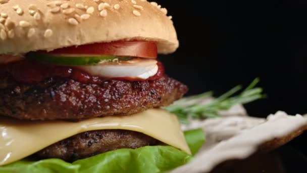 Pyszne hamburgery, fast food. Świeży domowej roboty grillowany burger z patty mięsa, pomidory, ogórek, sałata, cebula i nasiona sezamu. Niezdrowy styl życia. Tło żywnościowe. 4k — Wideo stockowe