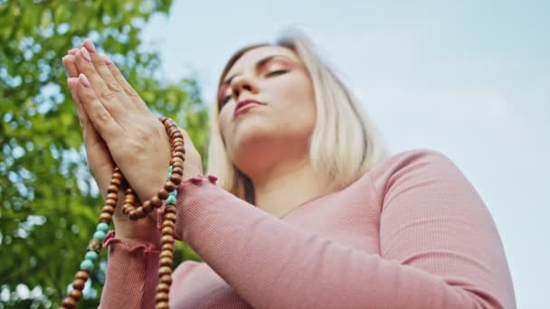 Le mani delle donne con perline di mala o rosario insieme simboleggiano preghiera e gratitudine. Mudra. Concetto di yoga. Ragazza concentrata in piedi con le mani in namaste e meditare o pregare . — Video Stock