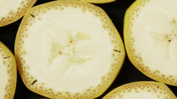 Makro widok plasterki banana rotacji. Ekstremalne zbliżenie soczystej, żółtej tekstury egzotycznych owoców. Pojęcie zdrowej żywności, produkty wegańskie. Kolorowe tło. — Wideo stockowe