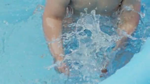 Mains d'enfants avec des canards en caoutchouc jaune éclabousse l'eau pendant la baignade dans la piscine à l'extérieur en été. Petit garçon qui s'amuse. Concept de mode de vie sain, famille, loisirs en été. Mouvement lent. — Video