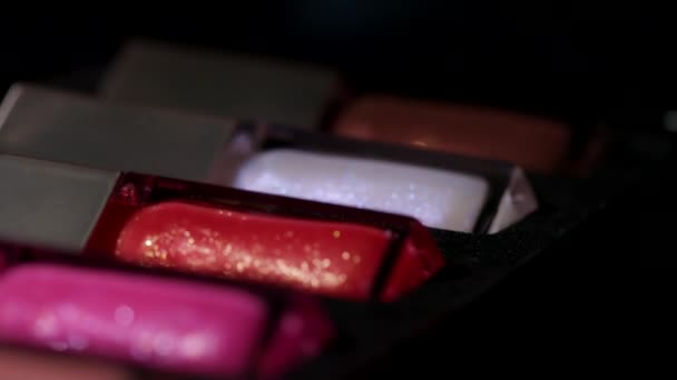 검은 배경 위에서 회전하는 유리병 안의 아름다운 색깔의 입술이 달려 있다. 반사되어 분리 된 액상 립스틱 . 미 (美), 화장품, 화장 개념. — 비디오