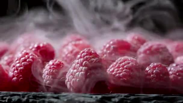Ripe chilled red raspberries with dry ice steam isolated on dark background. Dieting, vitamins, antioxidants concept. View of delicious dessert. — Stock Video
