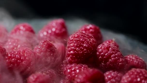 Reife gekühlte rote Himbeeren mit Trockeneisdampf isoliert auf dunklem Hintergrund. Ernährung, Vitamine, Antioxidantien. Blick auf köstliches Dessert. — Stockvideo